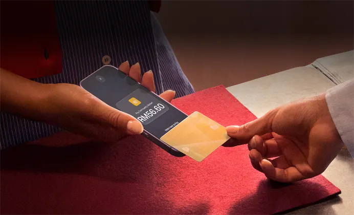 A hand taps a credit card to an iPhone to complete a payment