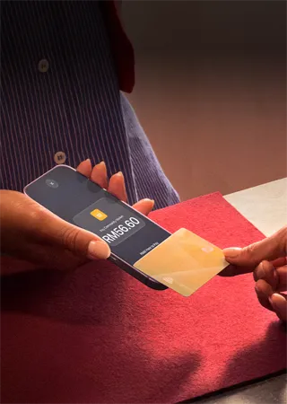 A hand taps a credit card to an iPhone to complete a payment
