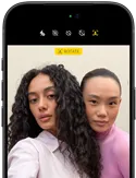 iPhone 18 Pro, black, front exterior, displaying two models posing for the camera, demonstrating the Center Stage front camera