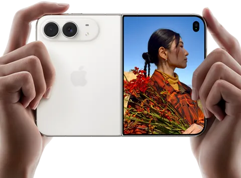 iPhone Duo, Star White colour, held by two hands in horizontal orientation, unfolded, left panel shows 48MP Dual Fusion rear cameras, right panel shows person getting their picture taken on outer display, the subject of the photo is able to see their face as their picture is getting taken using Duo Preview